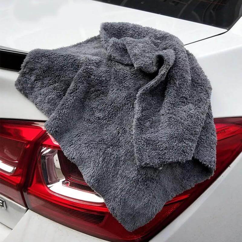 a gray color high plush edge-lessmicrofiber towel is placed on the backside of the car body covering the backlight of car.