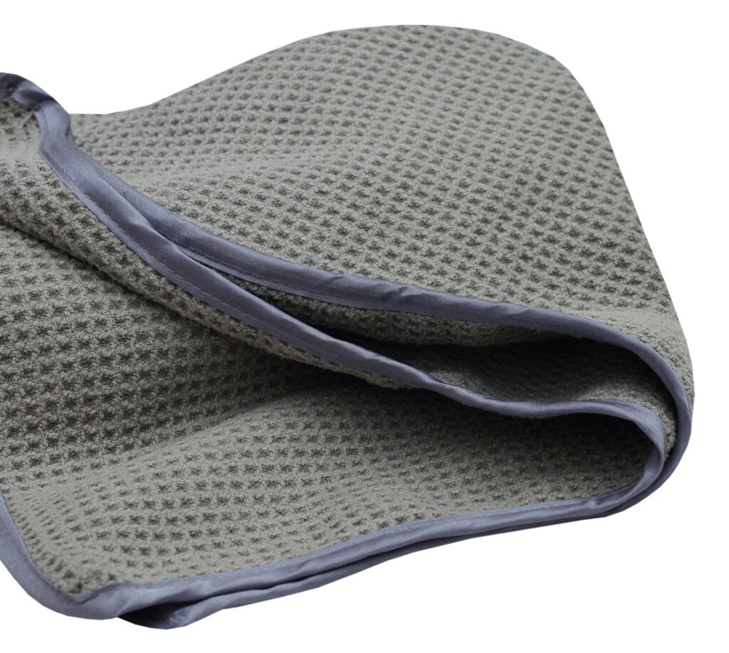 cropped image of a gray color waffle weave microfiber drying towel with satin edge.